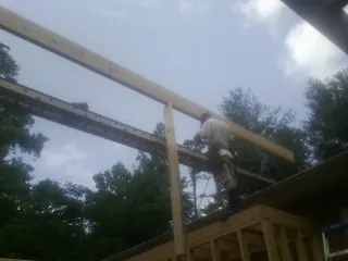 Carpenter setting a ridge beam over a new addition frame — Ice Dam Removal by Roofing Brothers in Cranesville