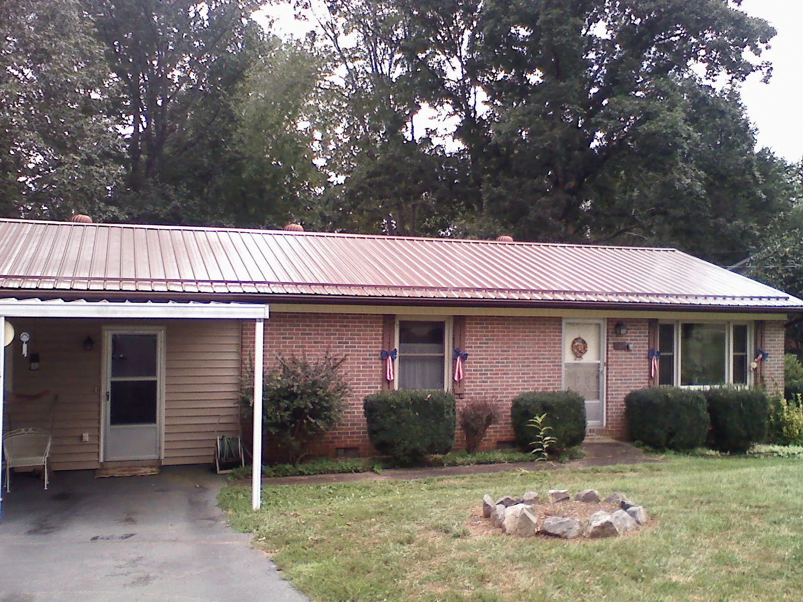 Bronze metal roof and carport on a brick ranch home — Roof Repair work by our crew in Cranesville